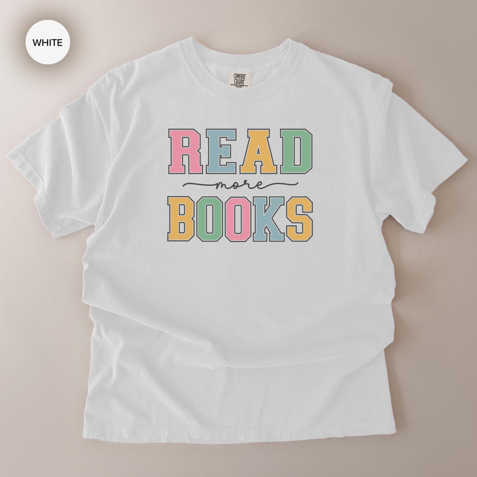 A white t-shirt with the text "READ more BOOKS" printed on it in a colorful, playful font.