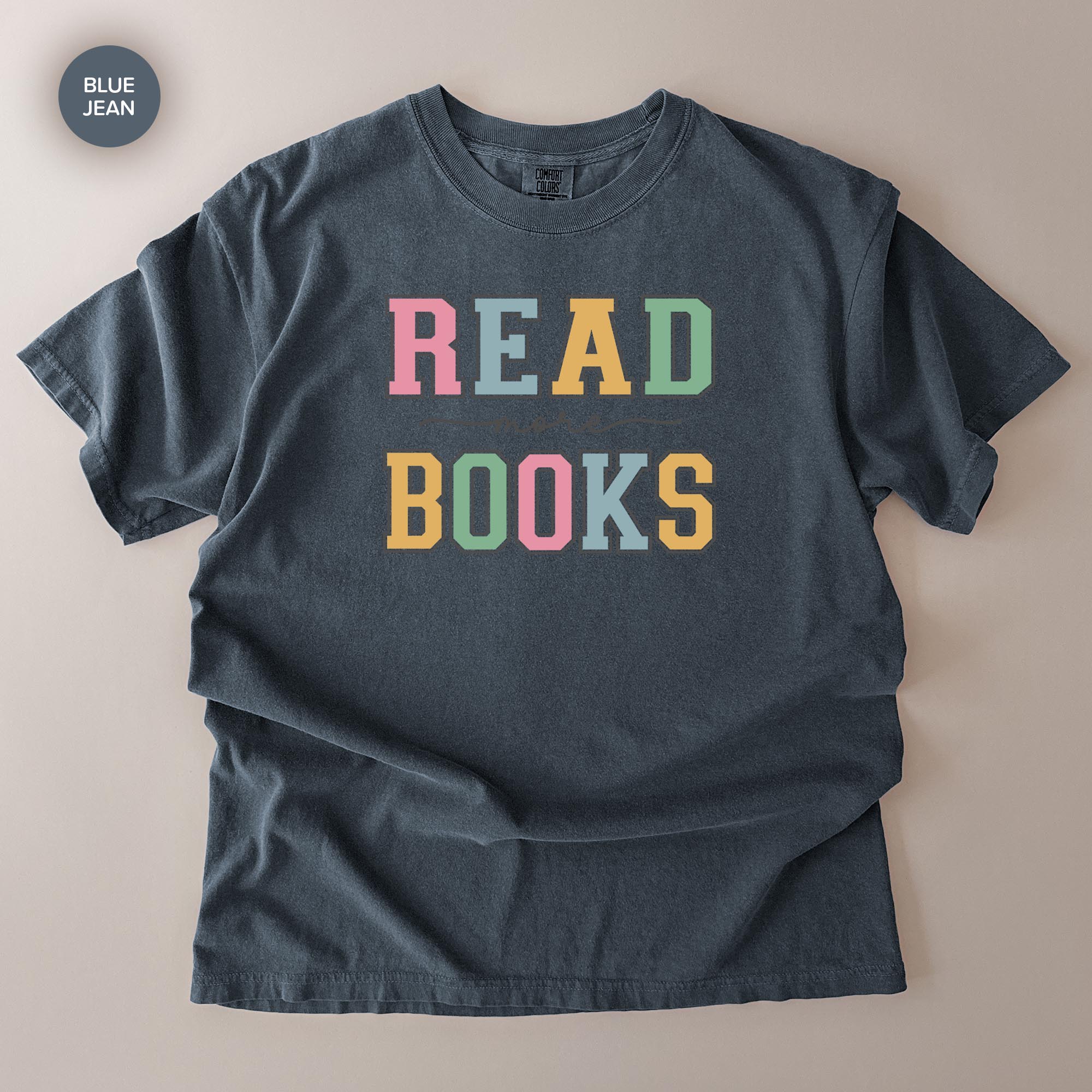 A gray t-shirt with the text "READ BOOKS" printed on it in a colorful, playful font.
