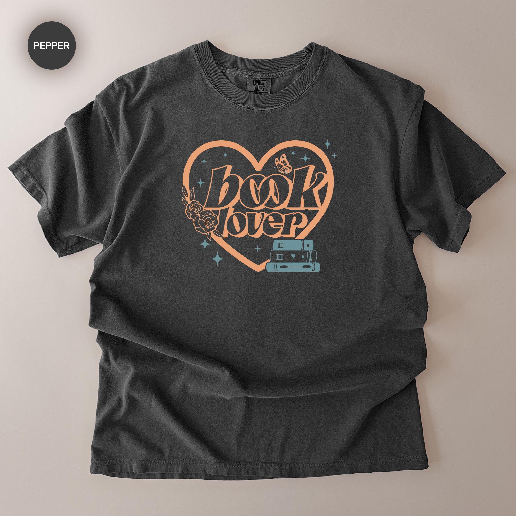 A black t-shirt with a graphic design featuring the text "book lover" and a heart shape with a butterfly and stars.