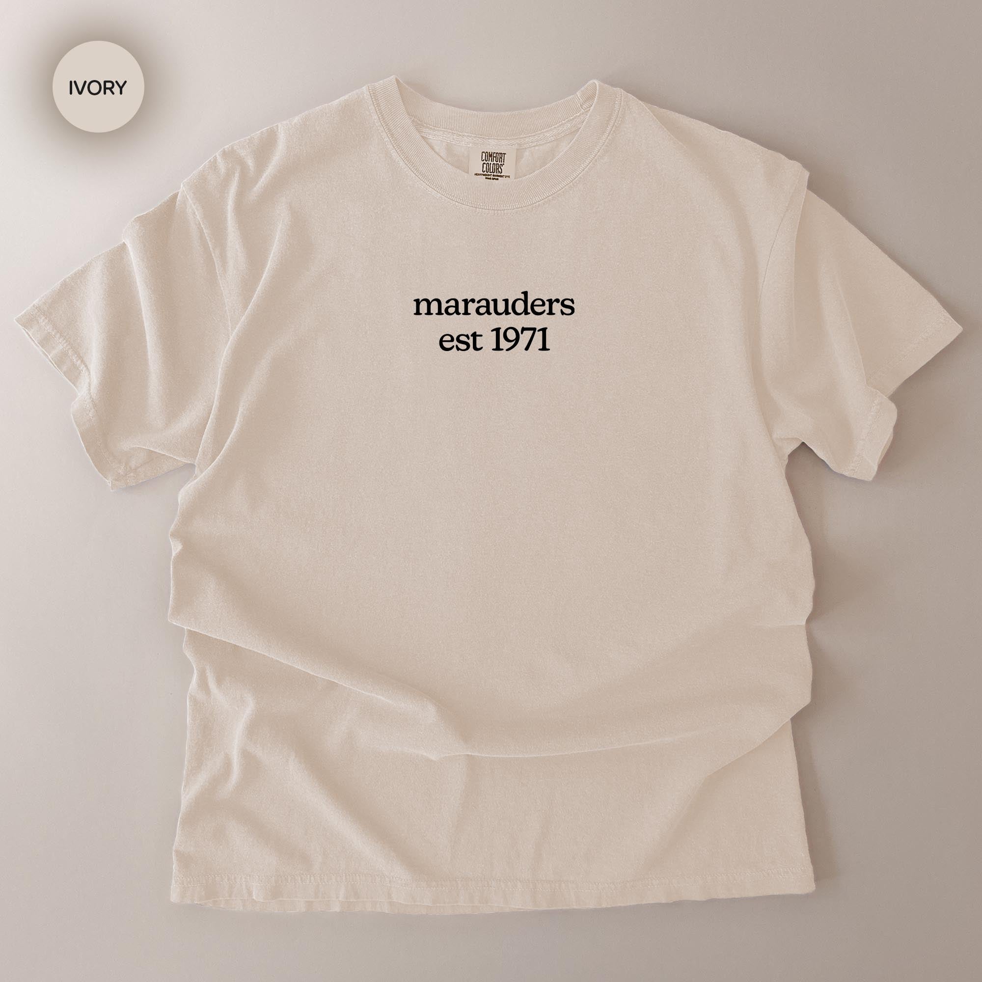 A white t-shirt with the text "marauders est 1971" printed on it.