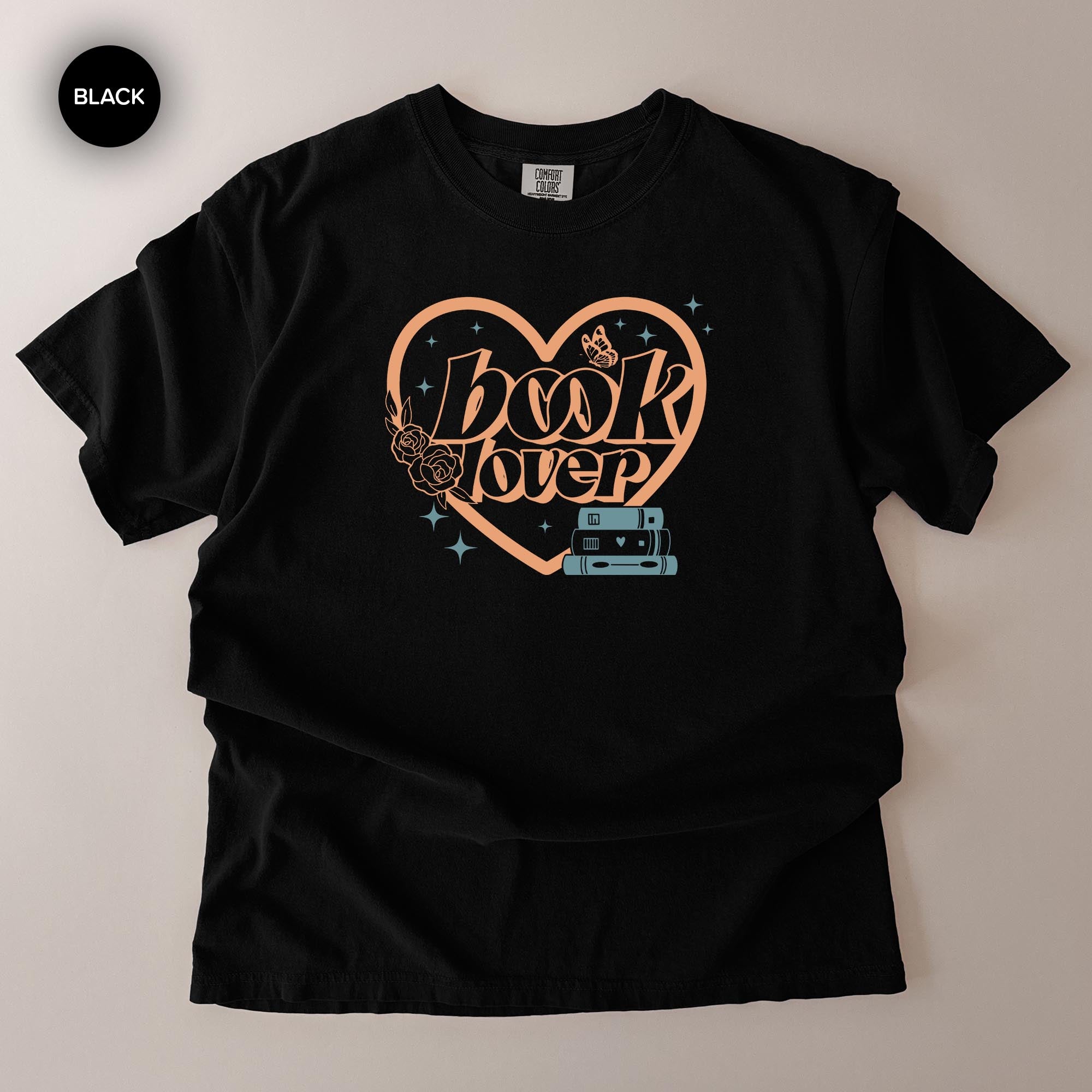 A black t-shirt with a graphic design featuring the text "book lover" and a heart-shaped symbol with a book and a rose.