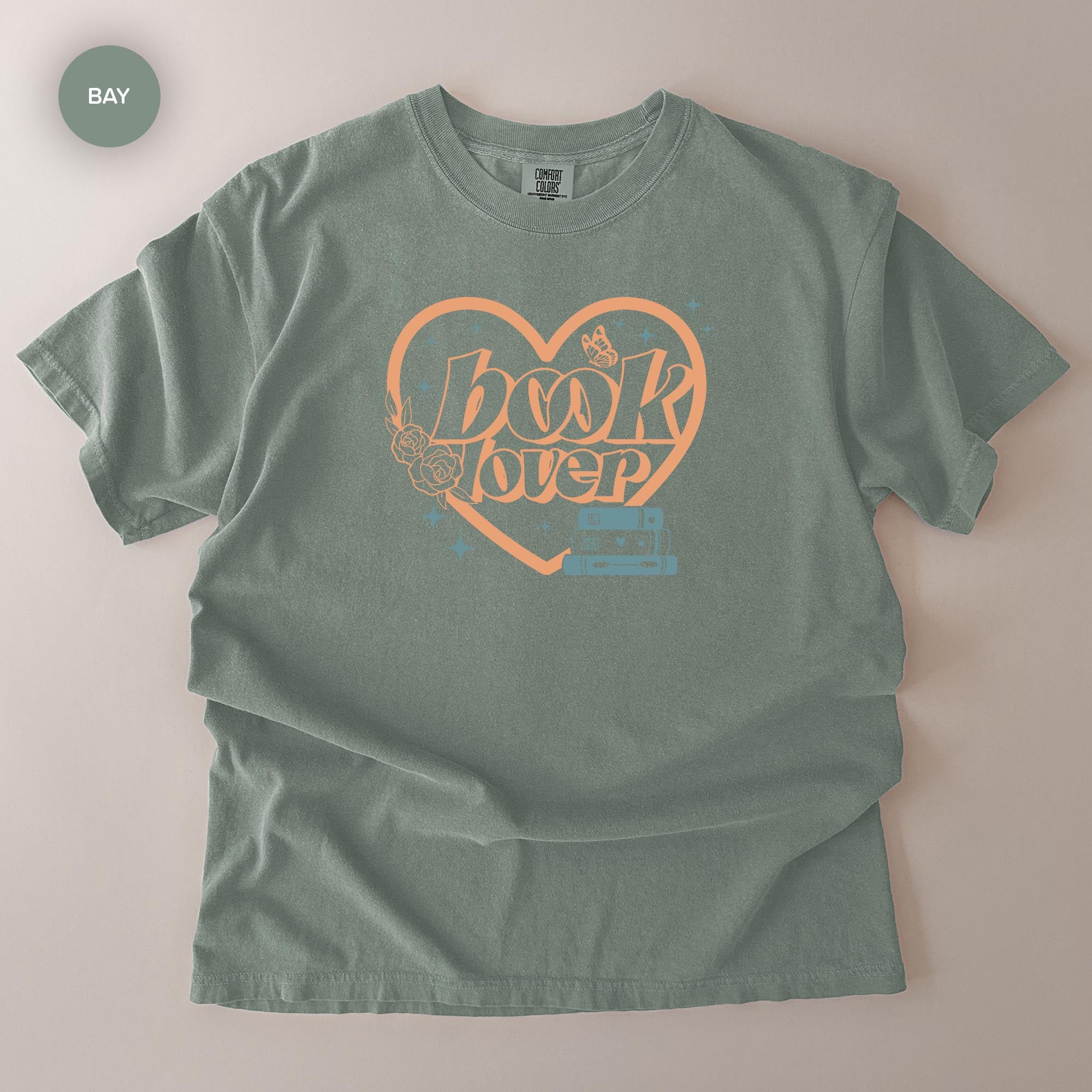 A gray t-shirt with a graphic design featuring the text "book lover" in a heart shape.