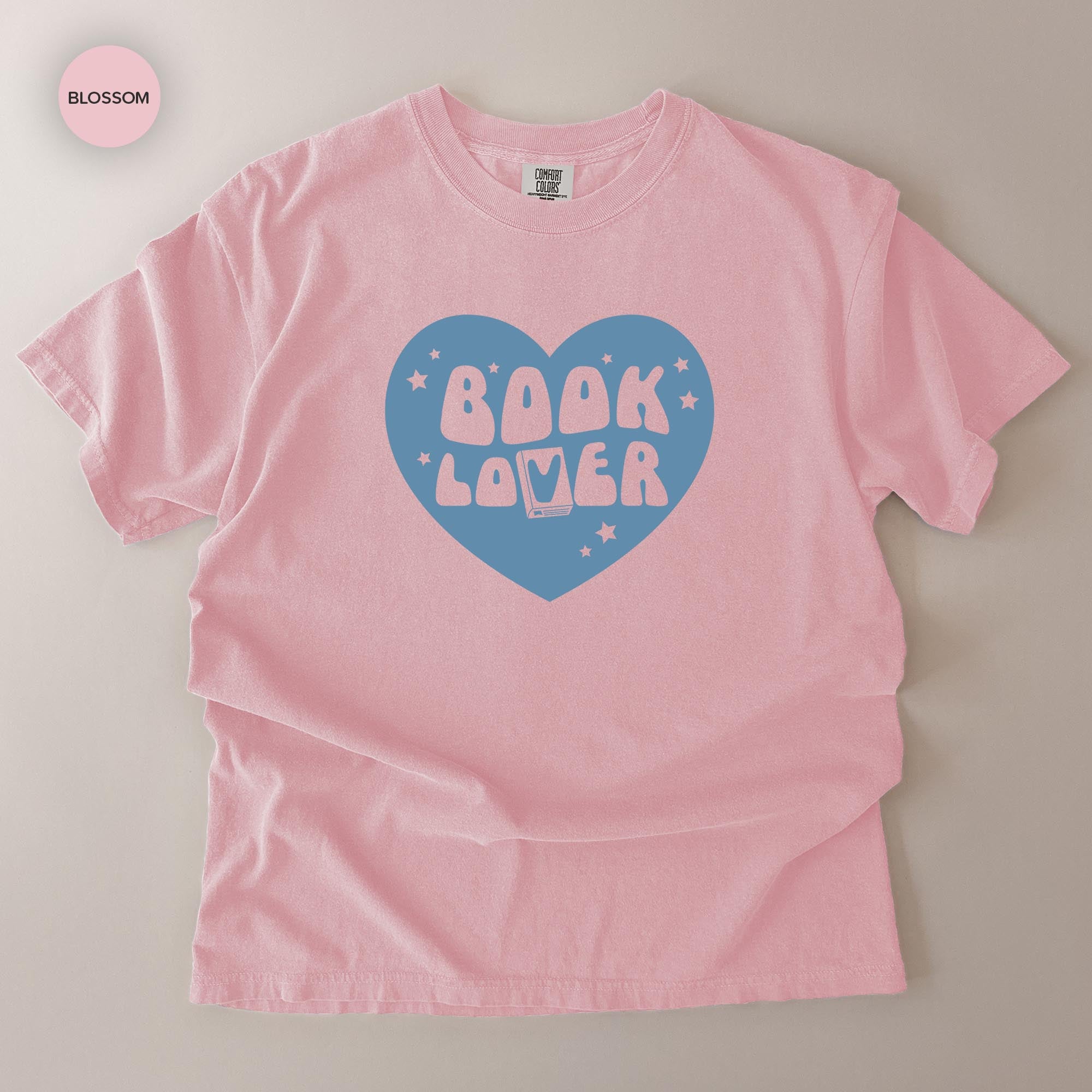 A pink t-shirt with a heart-shaped graphic and the text "BOOK LOVER" printed on it.