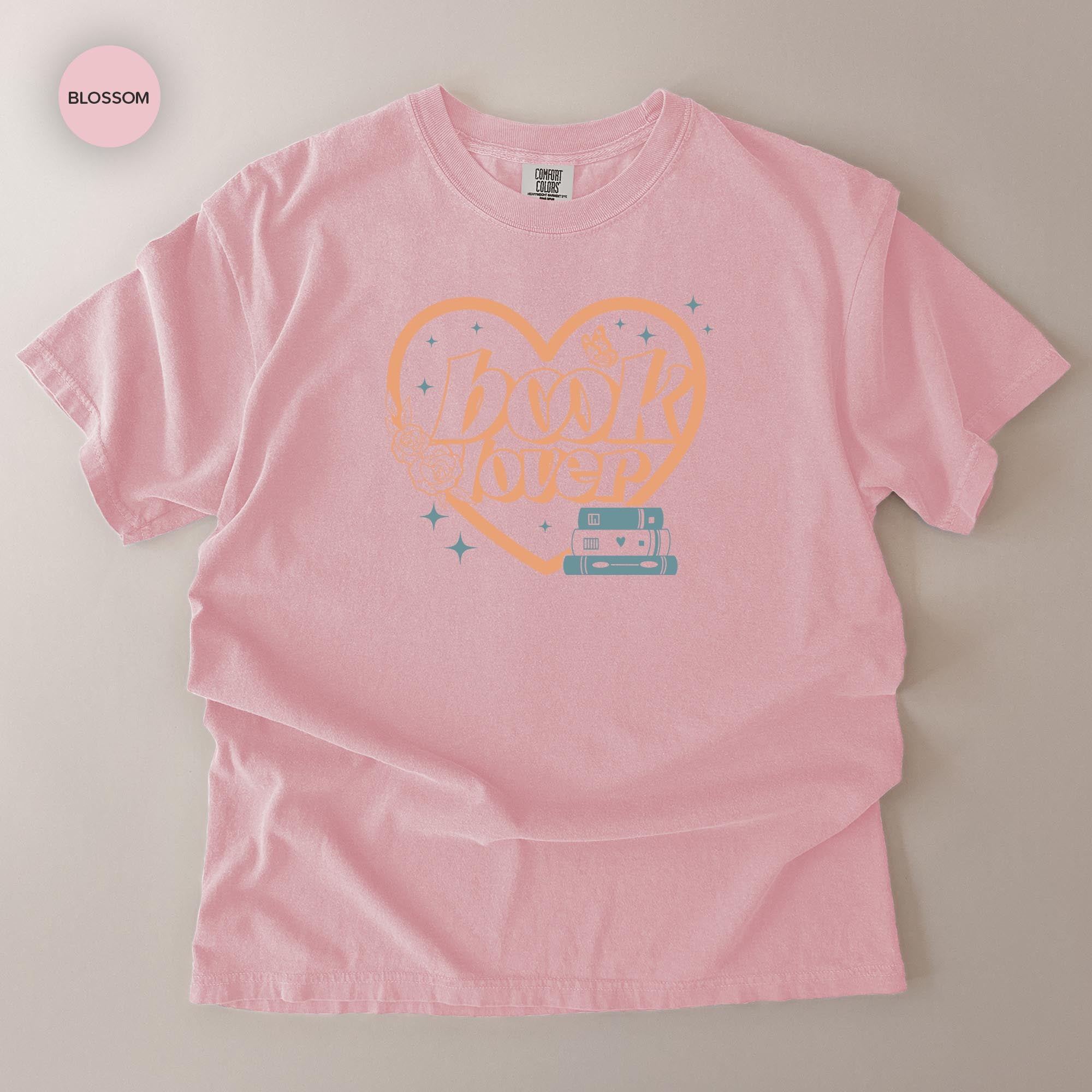 A pink t-shirt with a heart-shaped graphic and the text "Book Lover" printed on it.