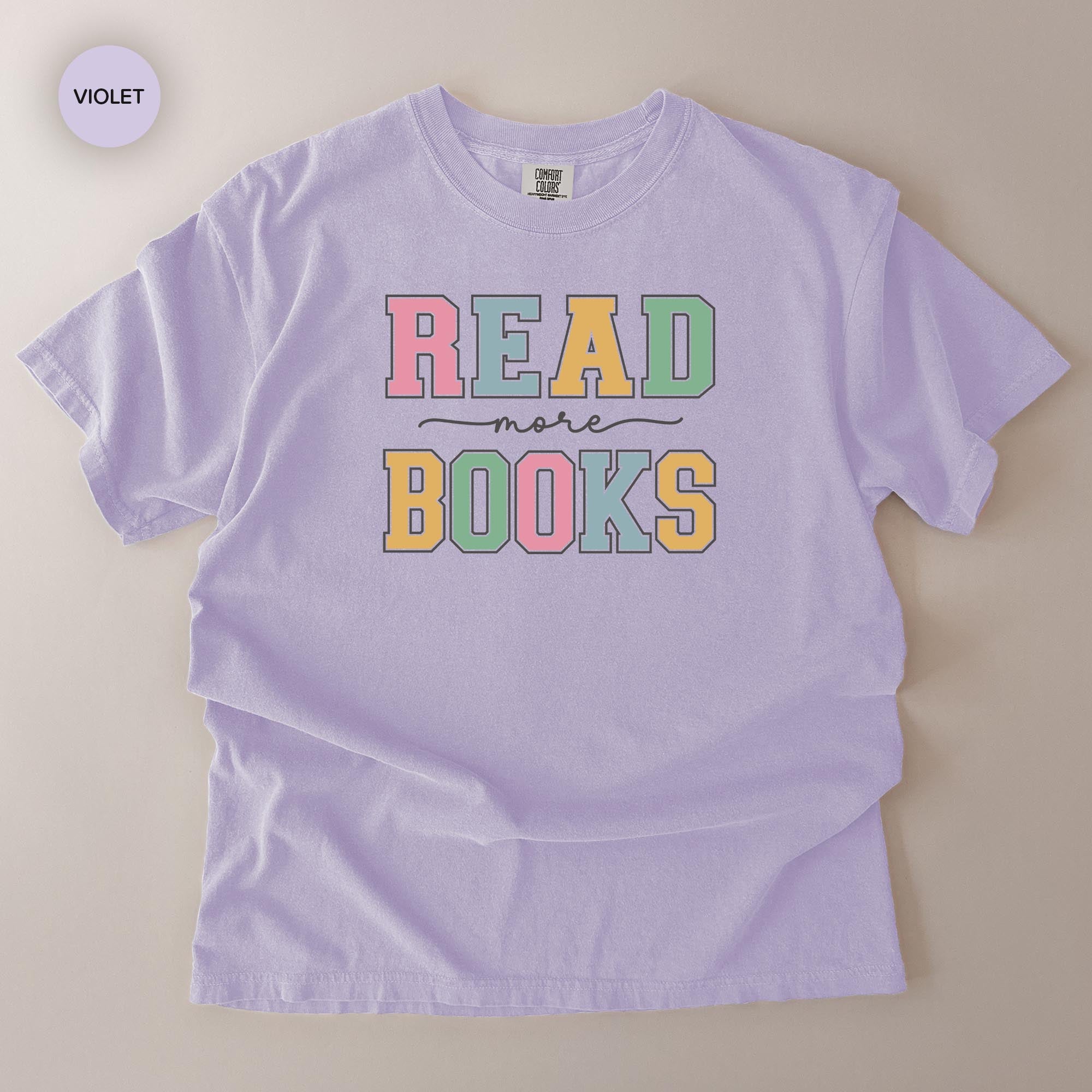 A purple t-shirt with the text "READ more BOOKS" printed on it.