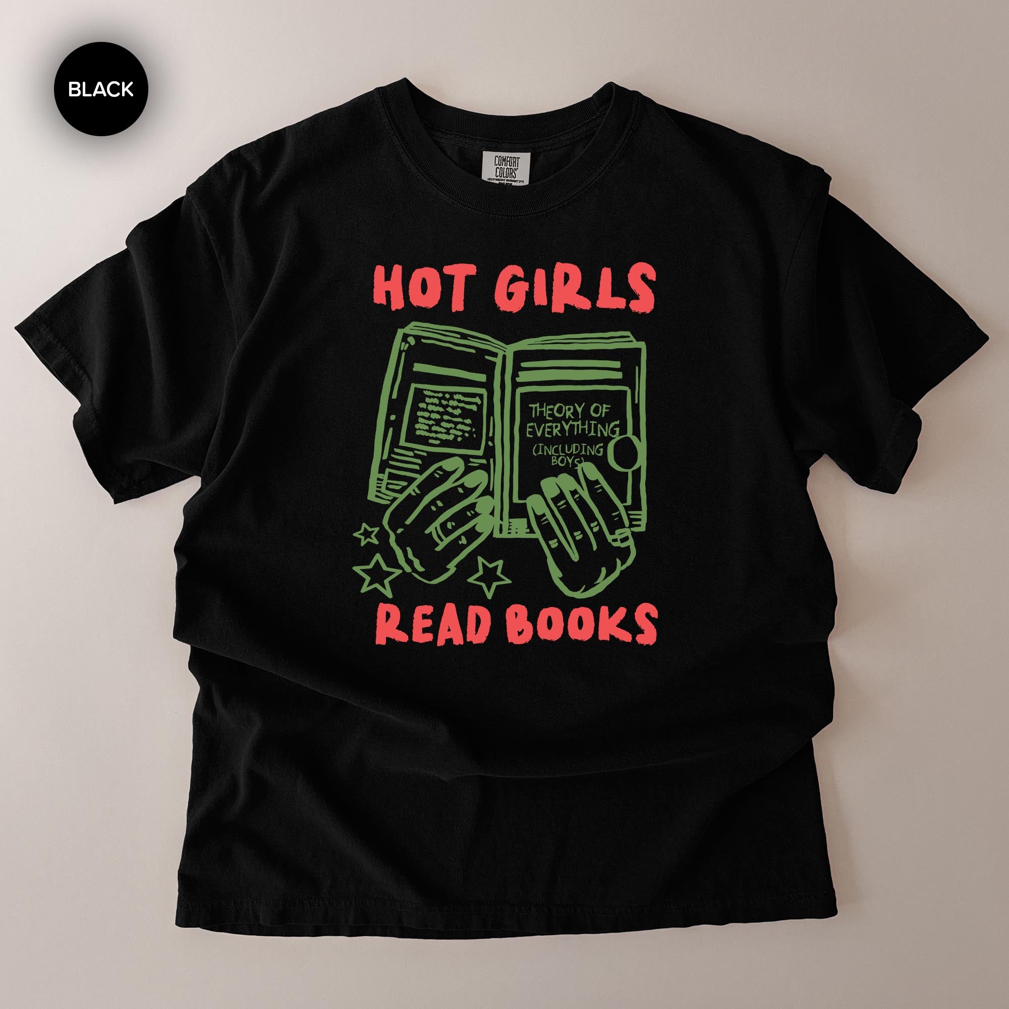 A black t-shirt with a graphic design featuring a pair of hands holding open a book, with the text "HOT GIRLS READ BOOKS" printed on it.