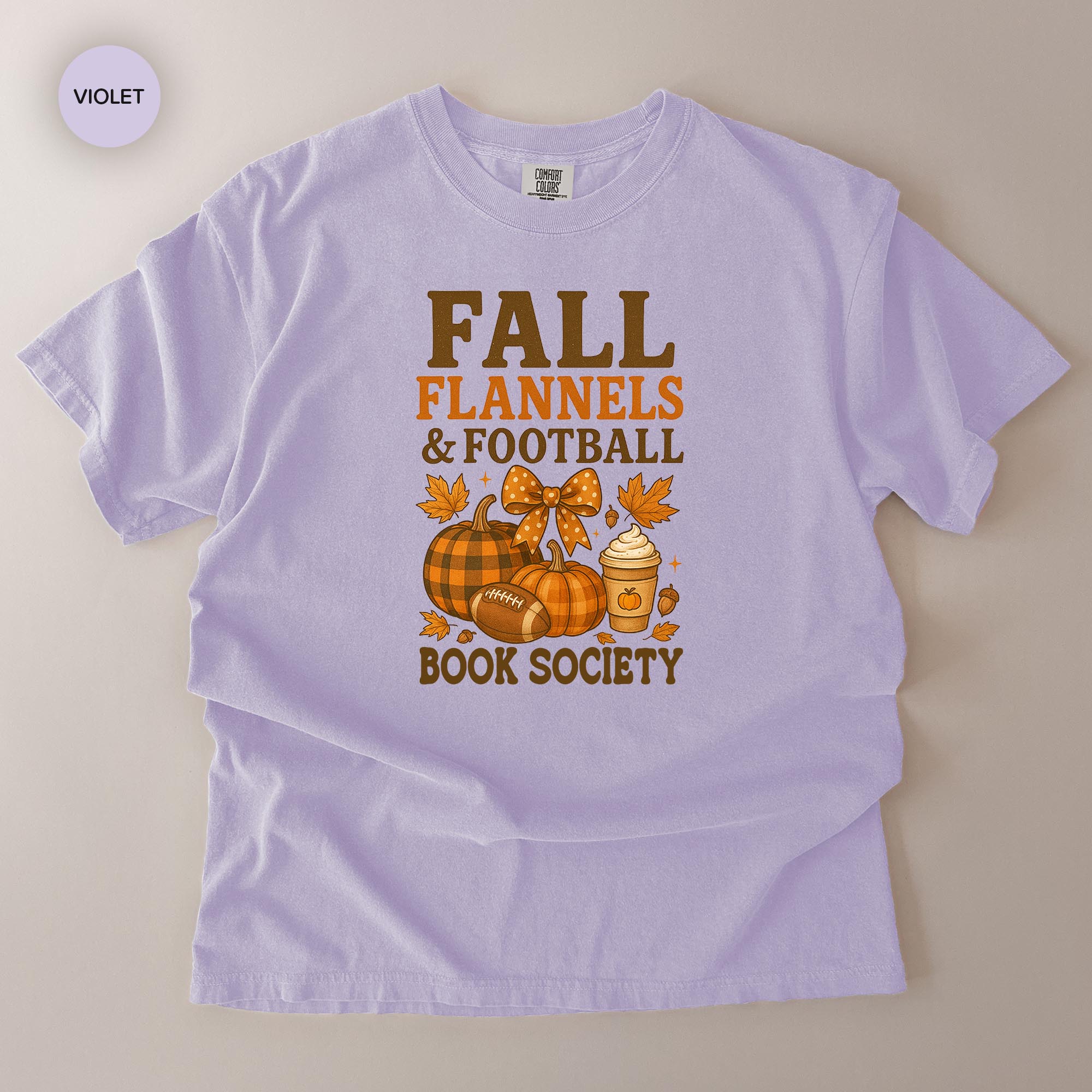 A white t-shirt with a graphic design featuring fall-themed elements such as pumpkins, leaves, and a football.