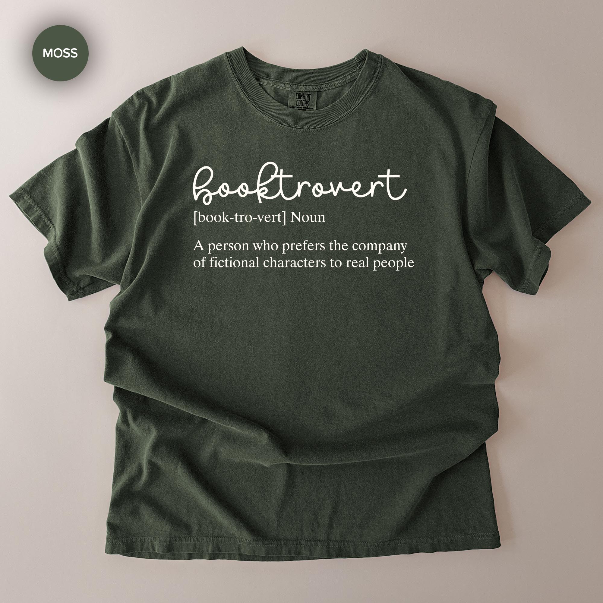 A green t-shirt with the definition of a book-hoarder printed on it.