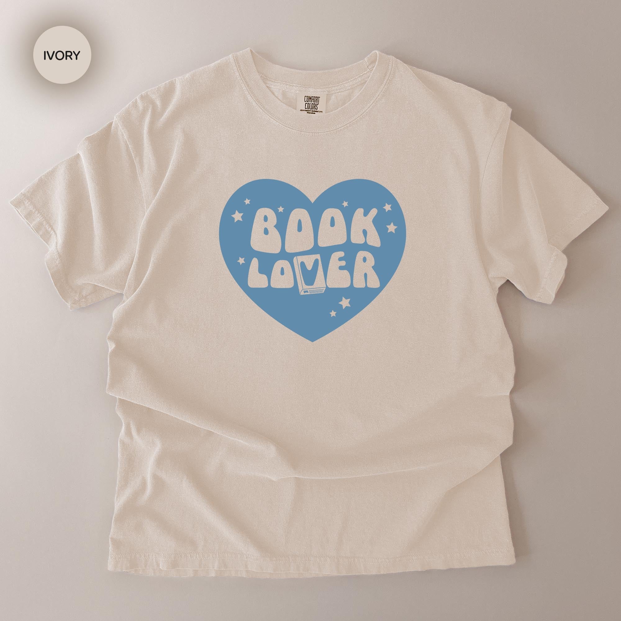 A white t-shirt with a blue heart-shaped graphic and the text "BOOK LOVER" printed on it.