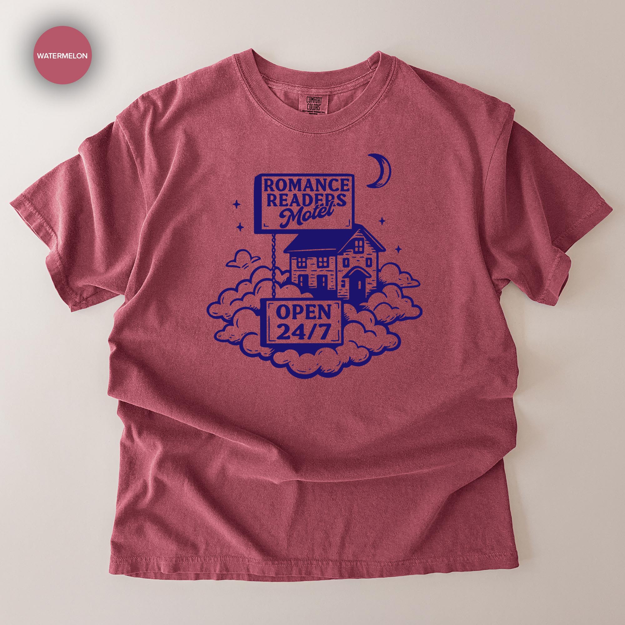 A red t-shirt with a graphic design featuring a house, clouds, and a crescent moon, along with the text "ROMANCE READERS MOILET" and "OPEN 24/7".