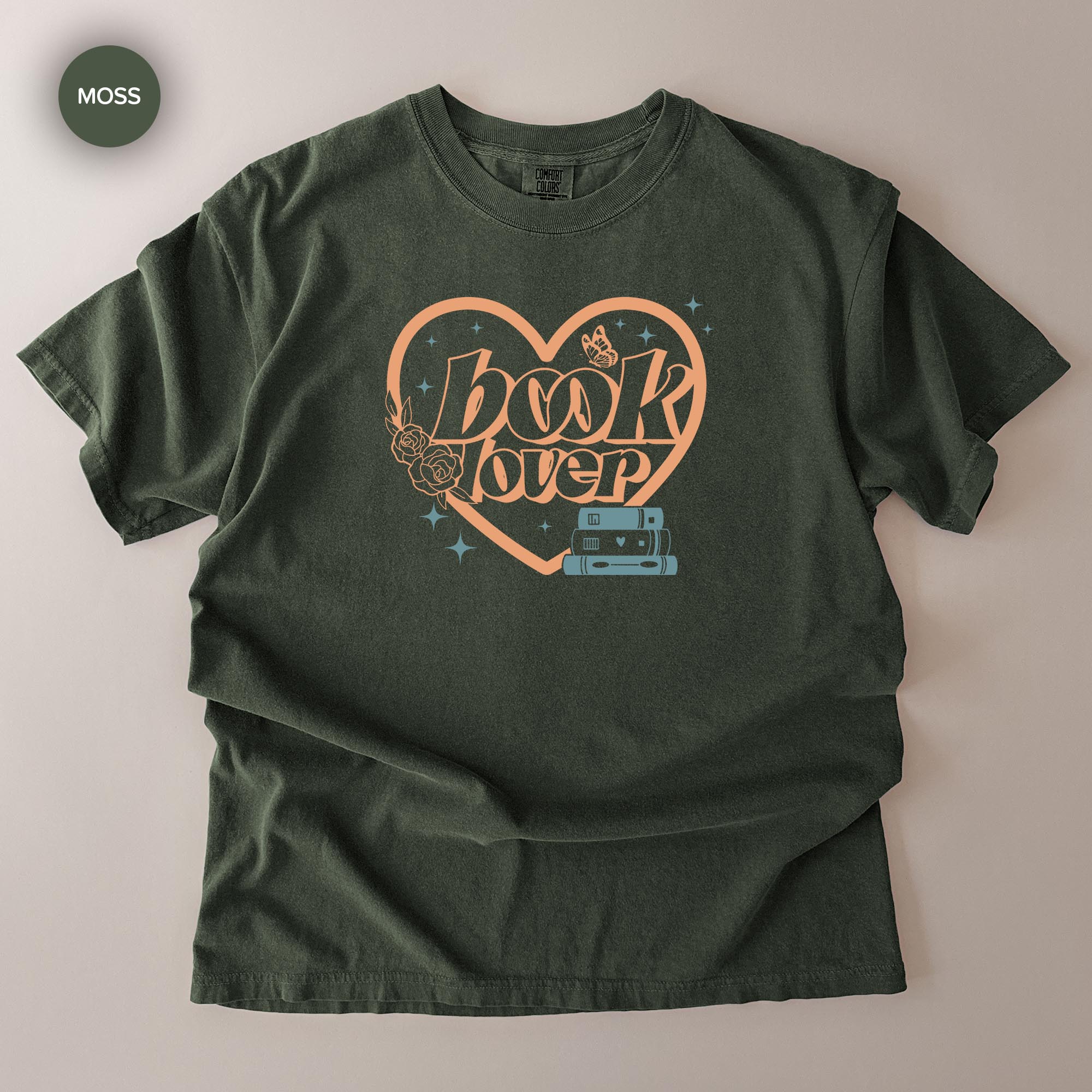 A green t-shirt with a graphic design featuring the text "book lover" and a heart-shaped symbol with a book and a butterfly.