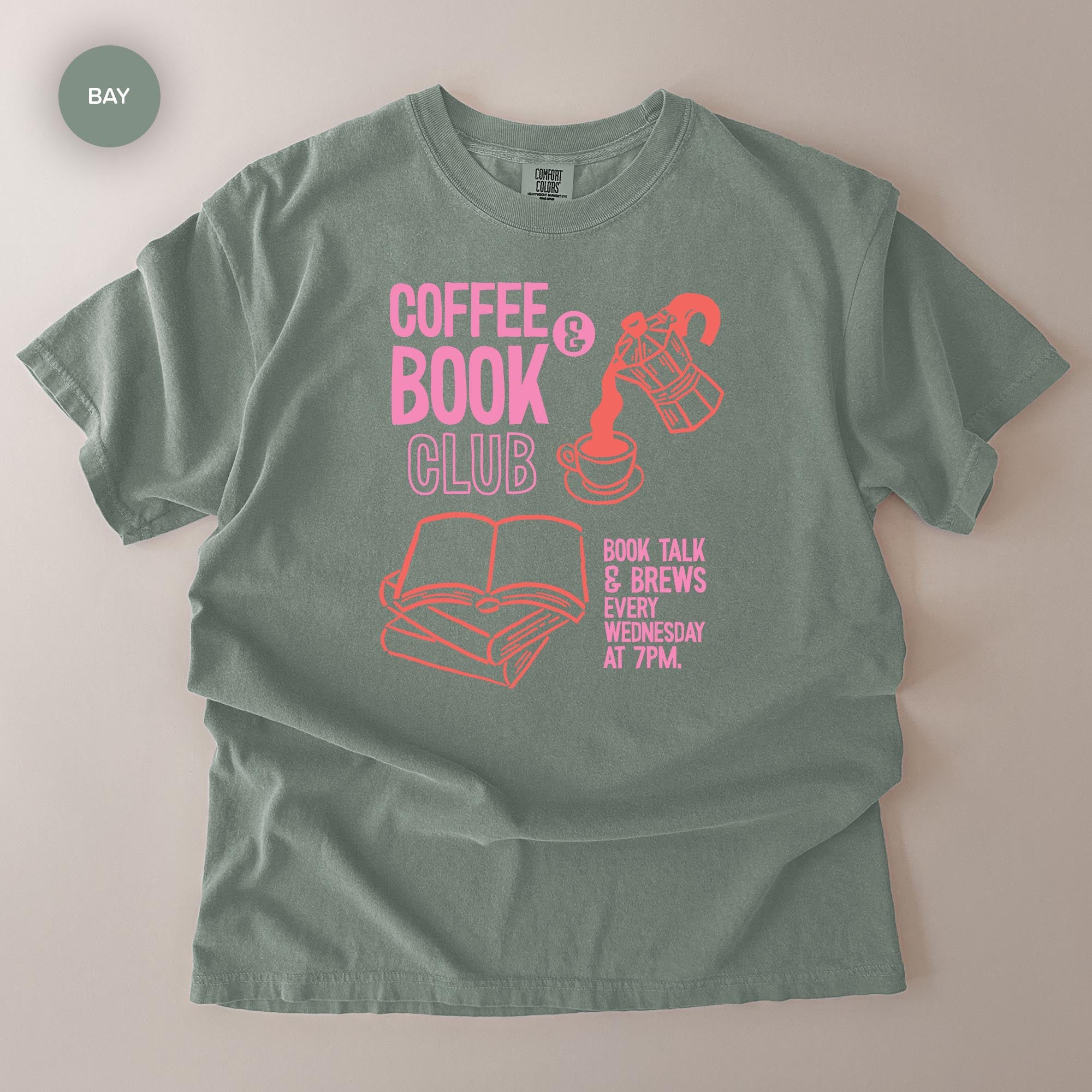 A gray t-shirt with a graphic design featuring a coffee cup, a book, and text promoting a book club event.