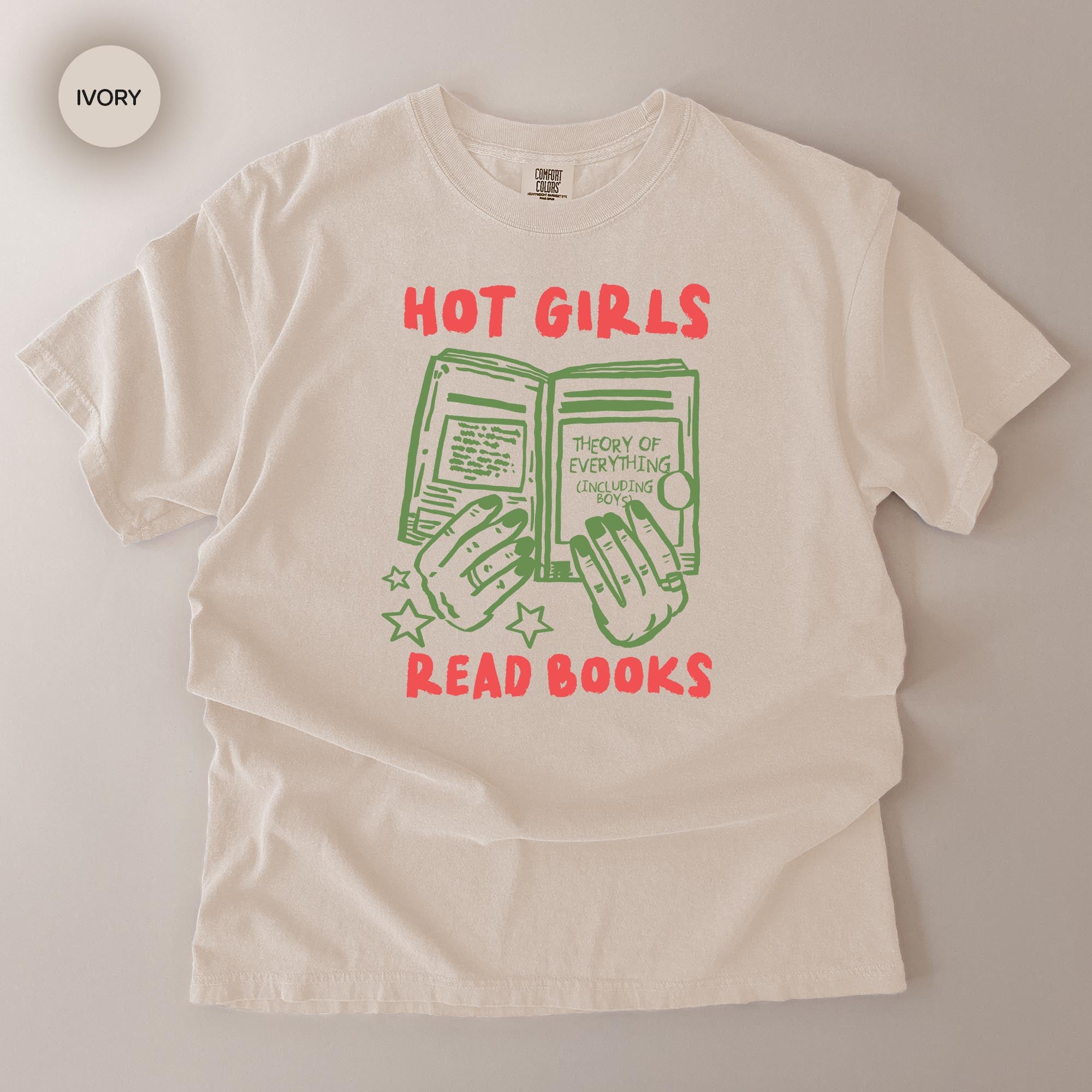 A white t-shirt with a graphic design featuring a pair of hands holding open a book, with the text "HOT GIRLS READ BOOKS" printed on it.