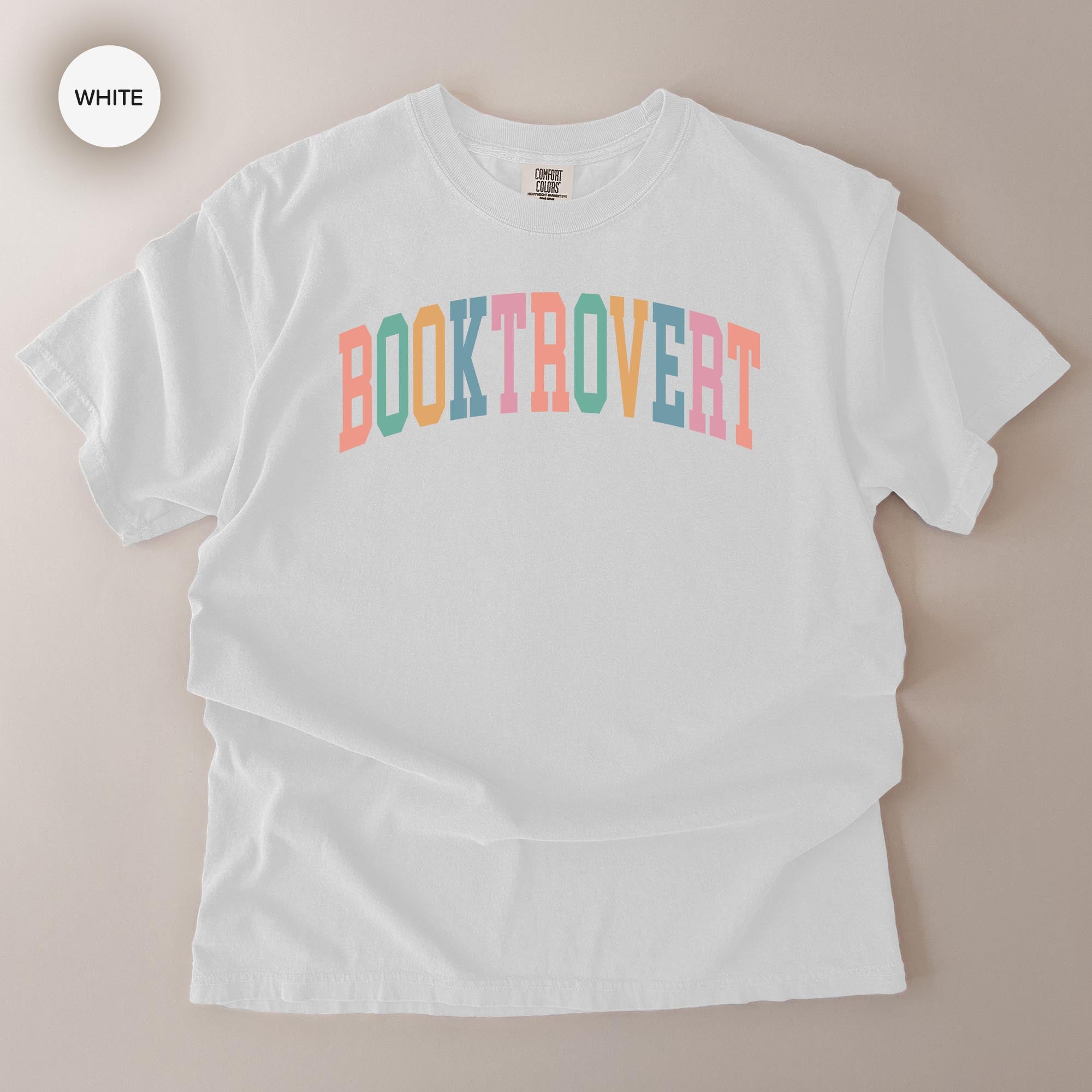 A white t-shirt with the text "BOOKTROVERT" printed on it in a colorful, vibrant font.
