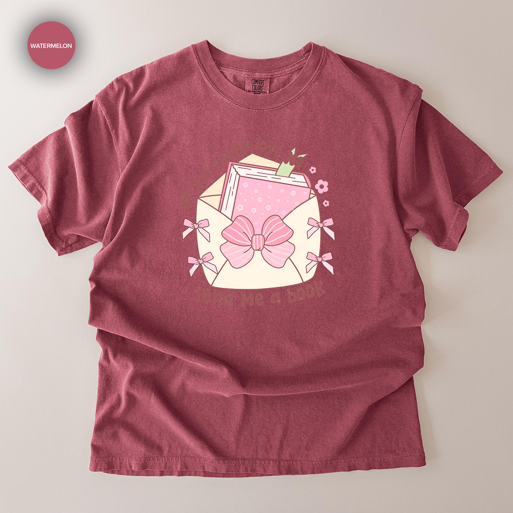 A red t-shirt with a graphic design depicting an envelope with a bow and the text "I love books" printed on it.