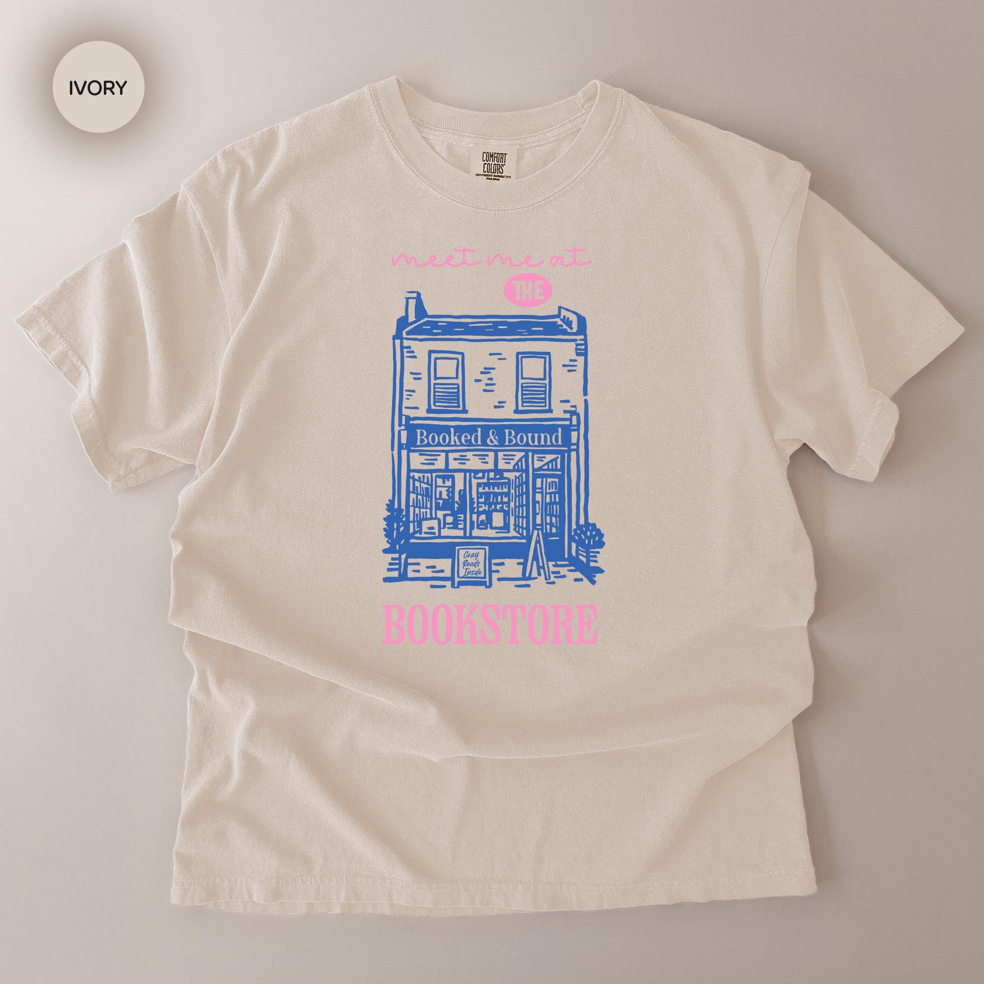 A white t-shirt with a graphic design depicting a building and the text "Booked & Bounded Books" printed on it.