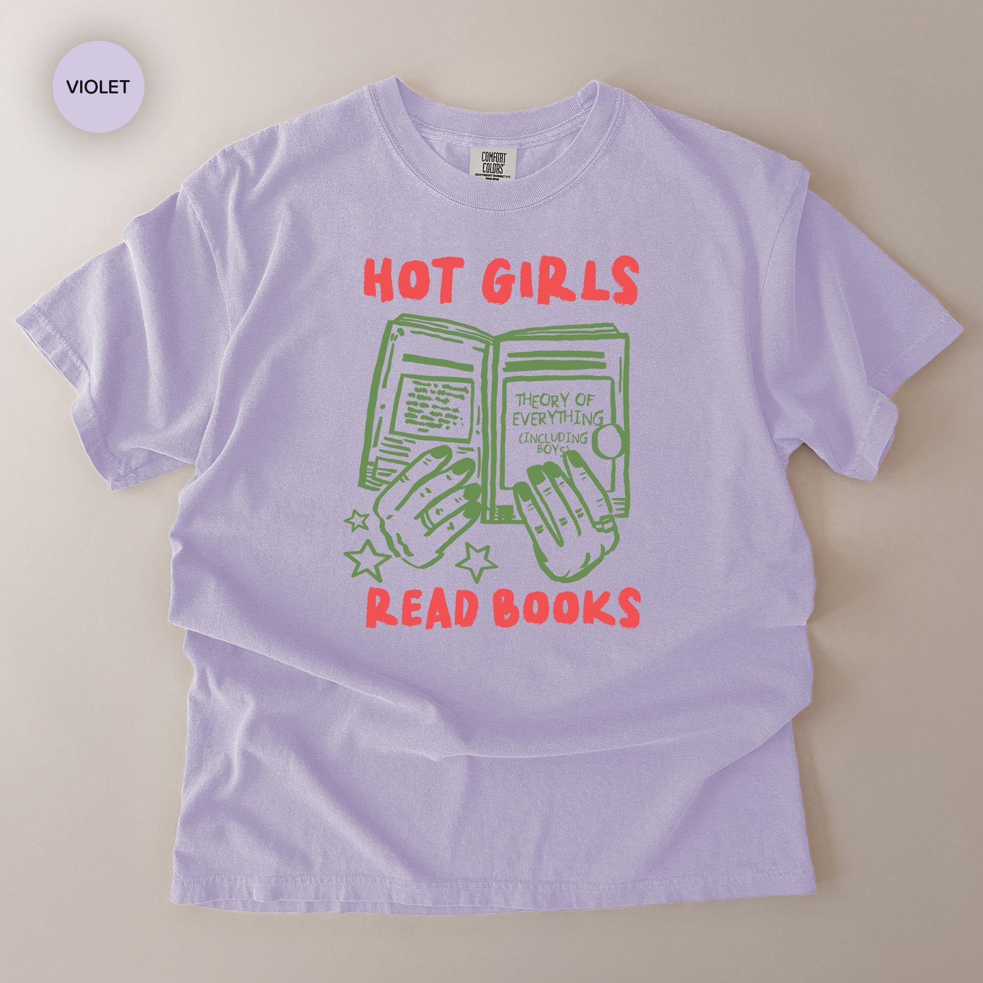 A purple t-shirt with a graphic design featuring a pair of hands holding open a book, with the text "HOT GIRLS READ BOOKS" printed on it.