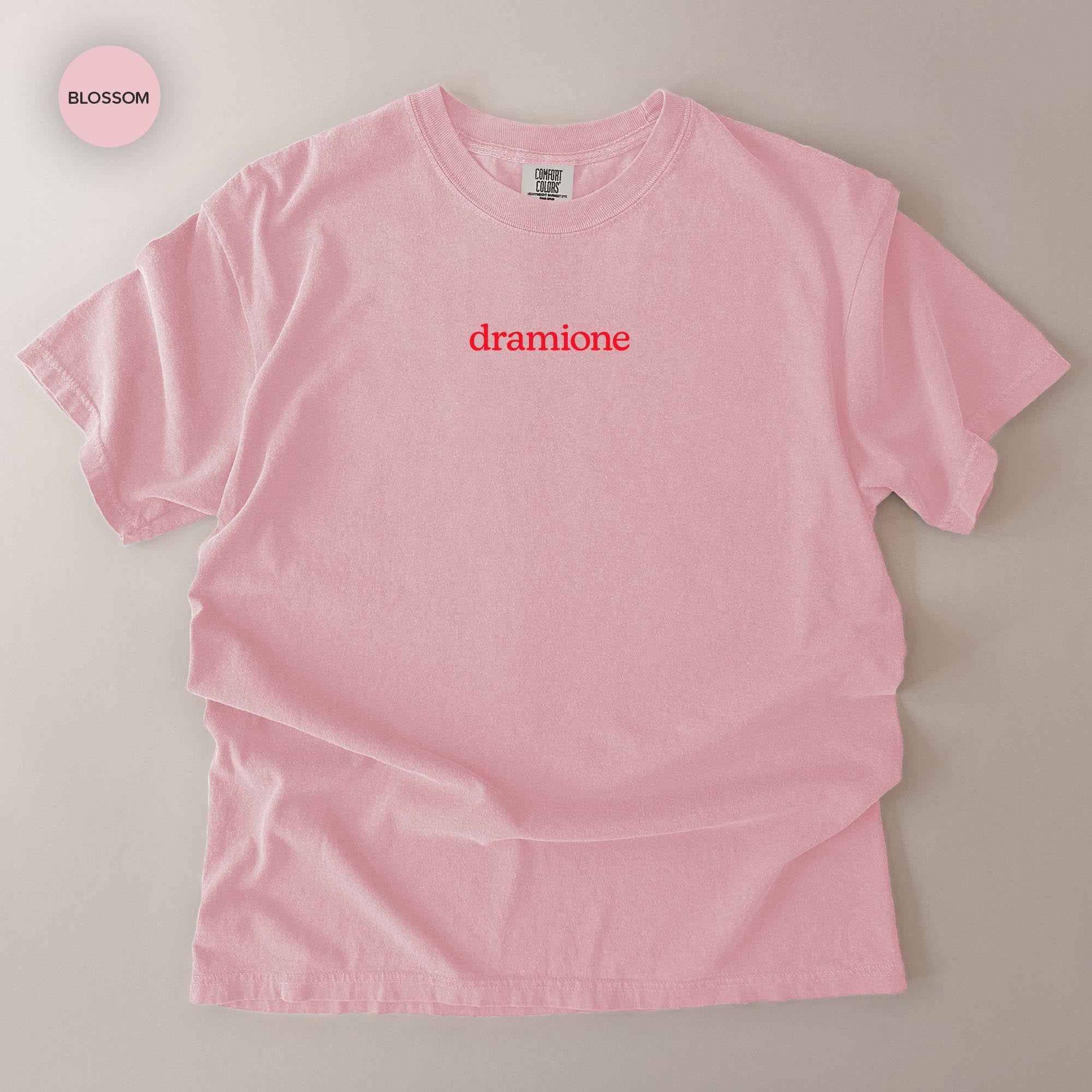 A pink t-shirt with the word "dramone" printed on it in red text.