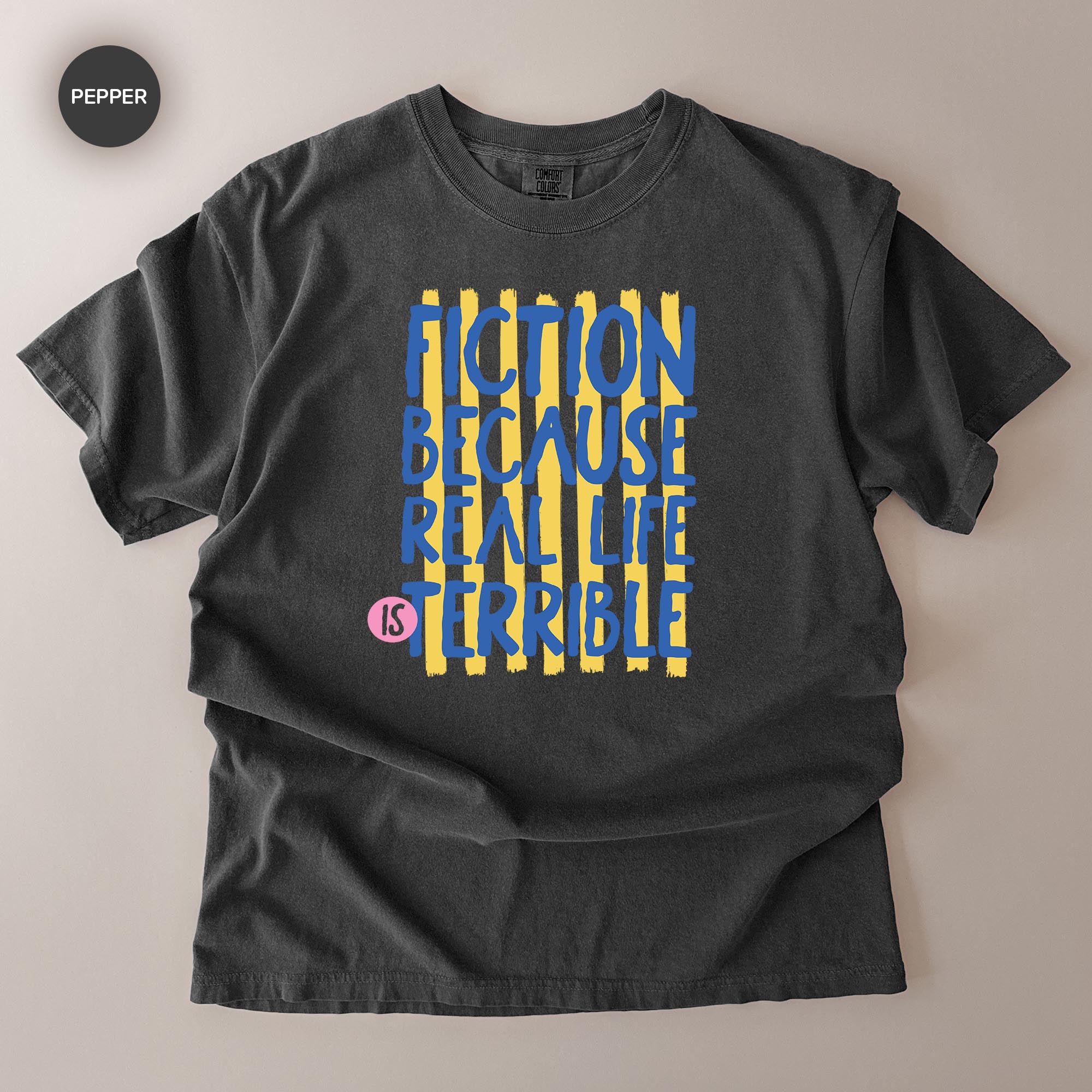 A black t-shirt with a graphic design featuring the text "FICTION BECAUSE REAL LIFE IS TERRIBLE" in a bold, stylized font.