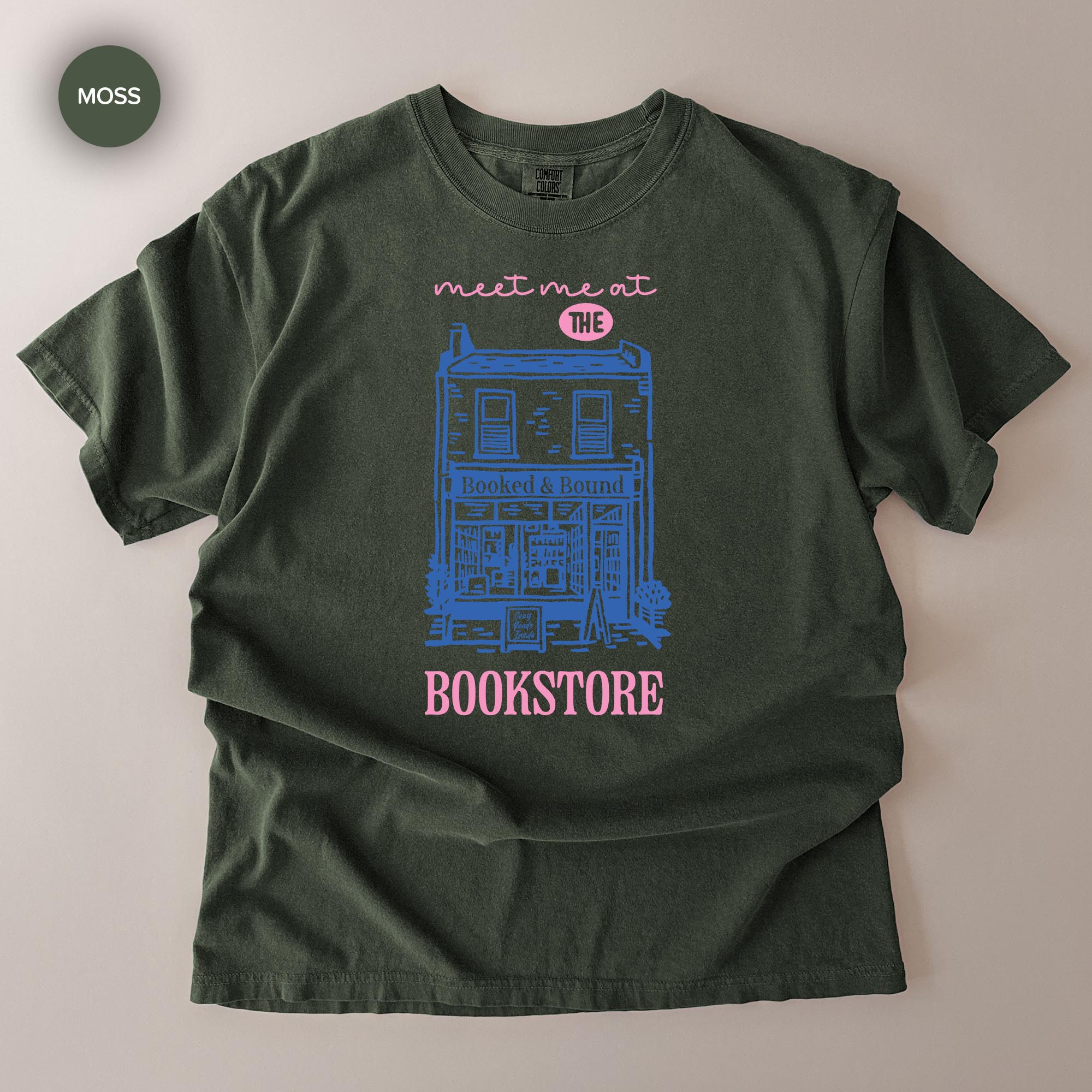 A green t-shirt with a graphic design depicting a building and the text "Bookstore" printed on it.
