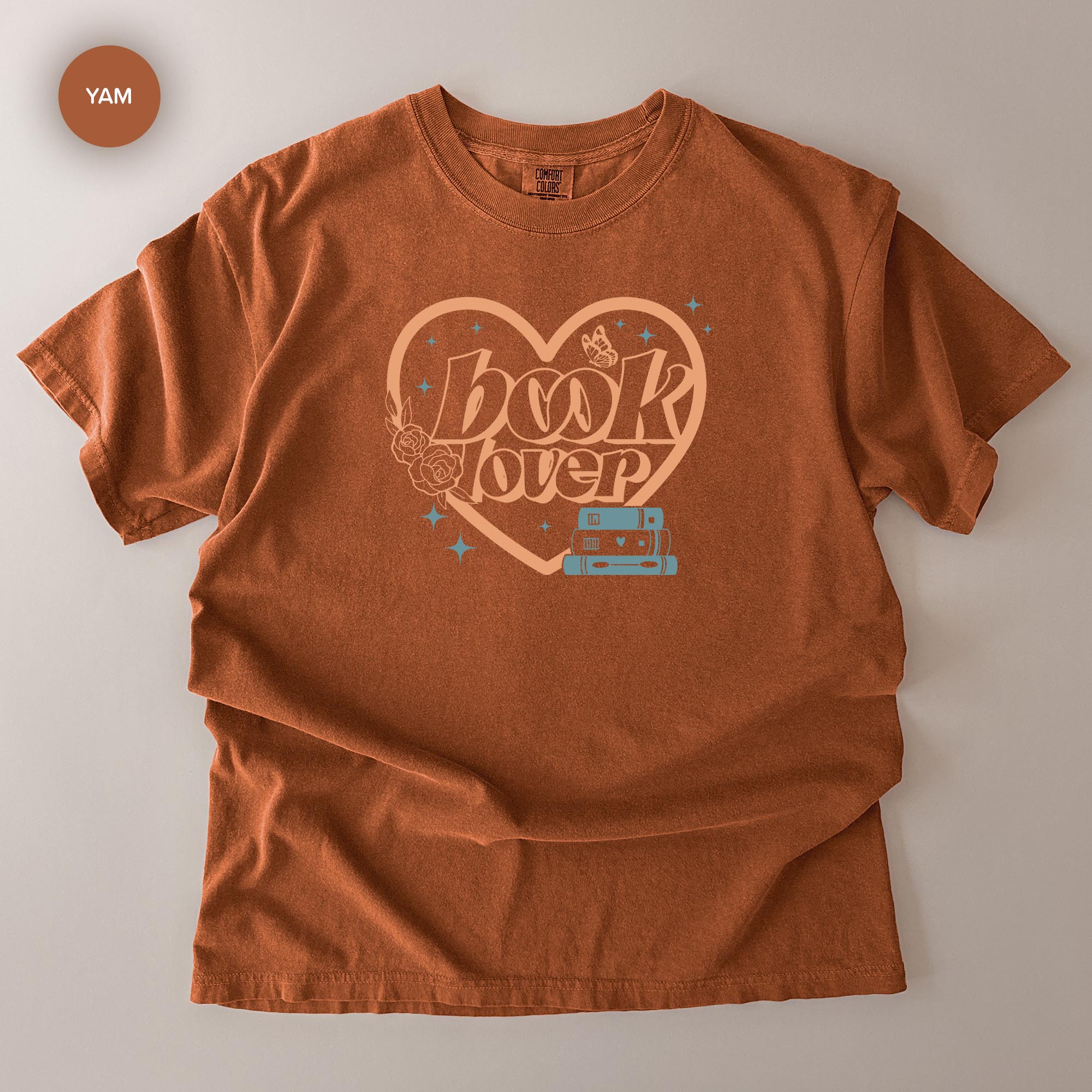 a brown t-shirt with a graphic design featuring the text "book lover" and a heart shape with stars around it.
