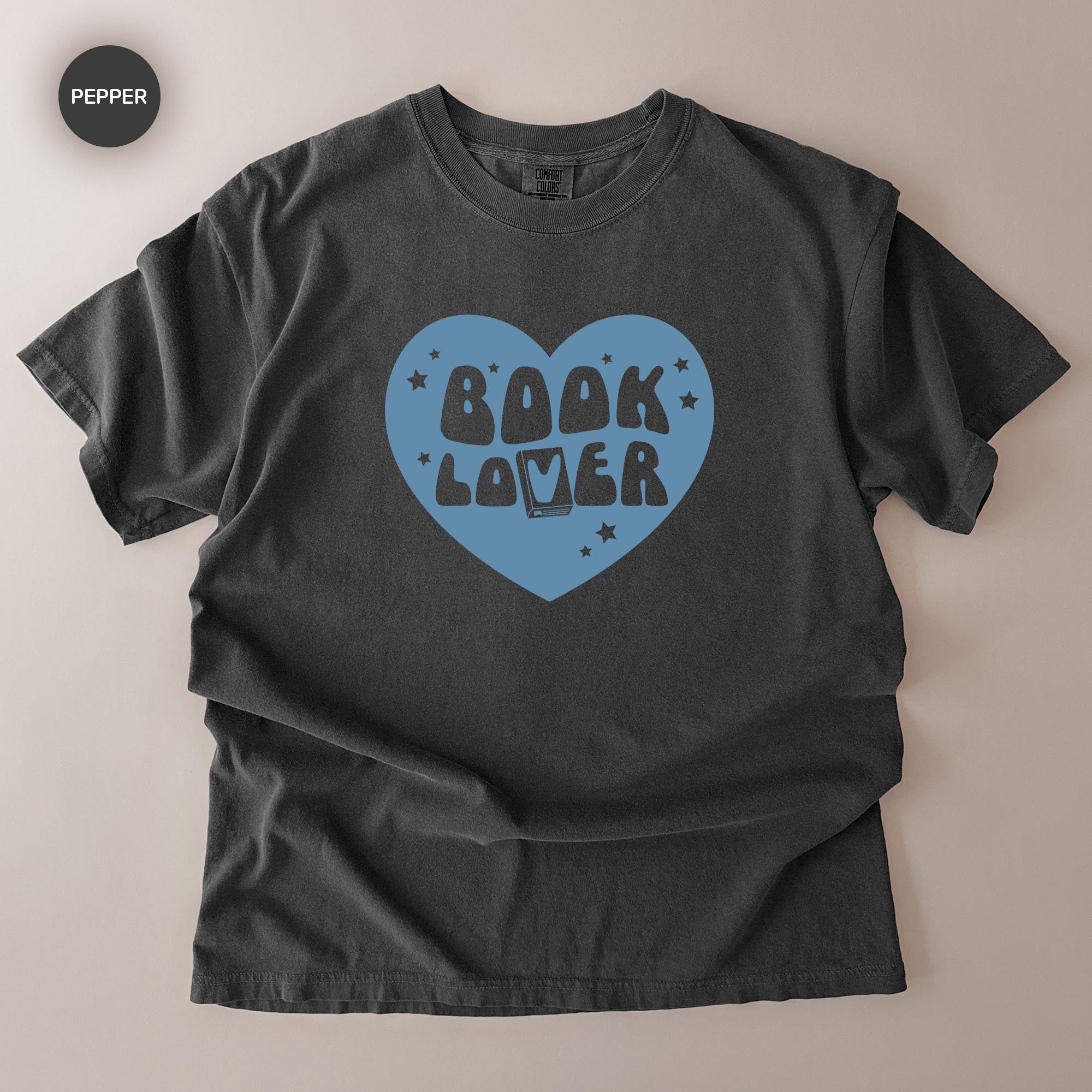 A gray t-shirt with a blue heart-shaped graphic and the text "BOOK LOVER" printed on it.