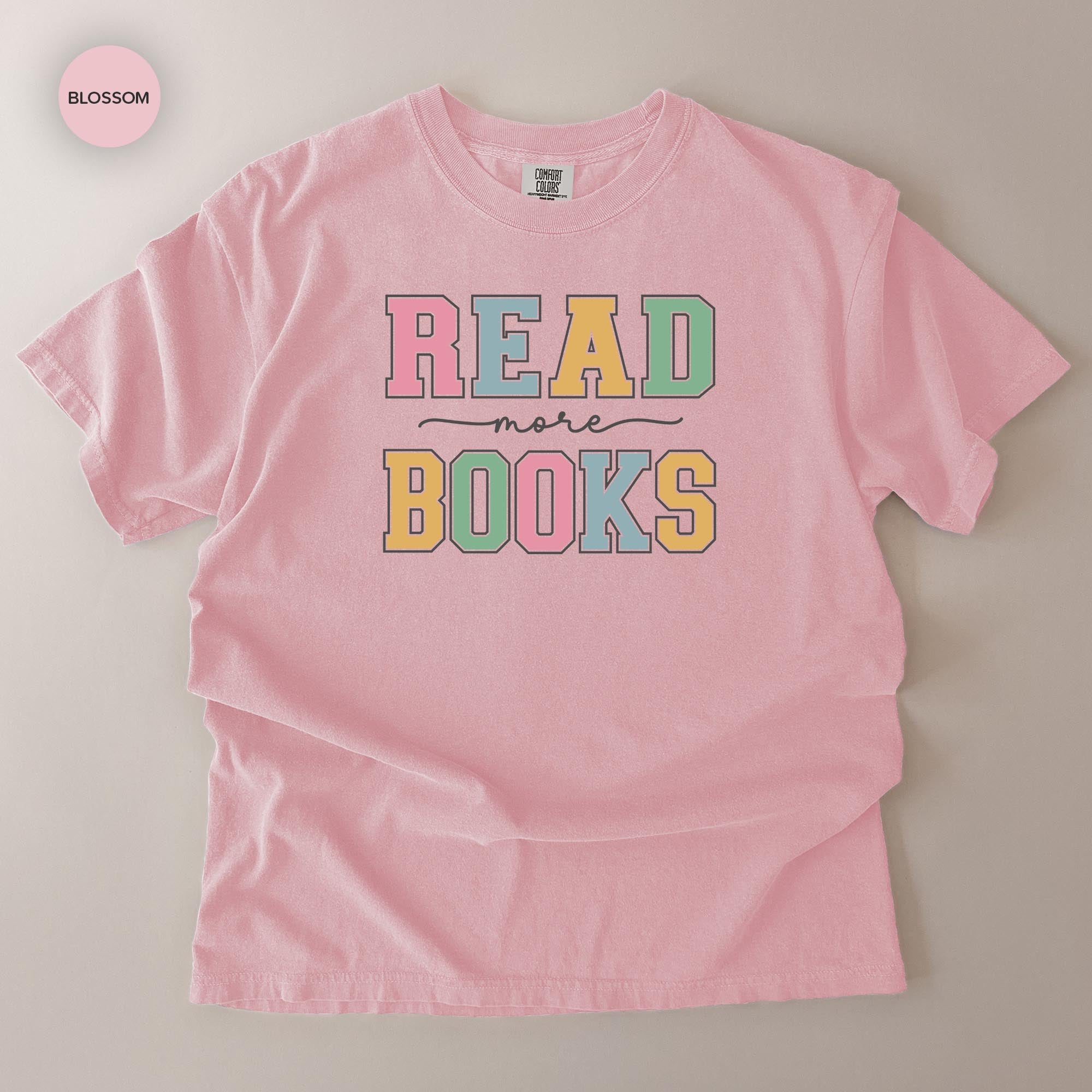 A pink t-shirt with the text "READ more BOOKS" printed on it.
