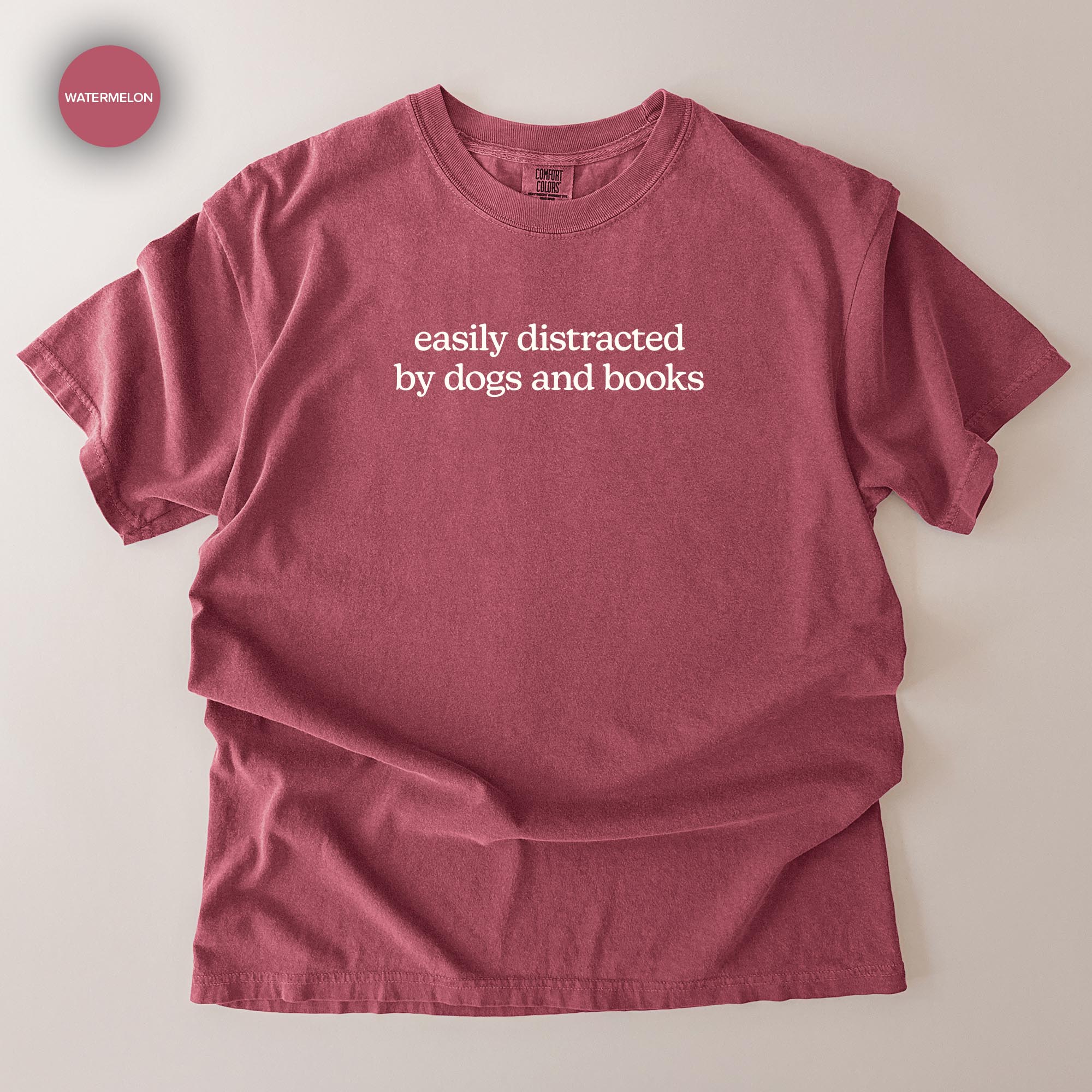 A red t-shirt with the text "easily distracted by dogs and books" printed on it.