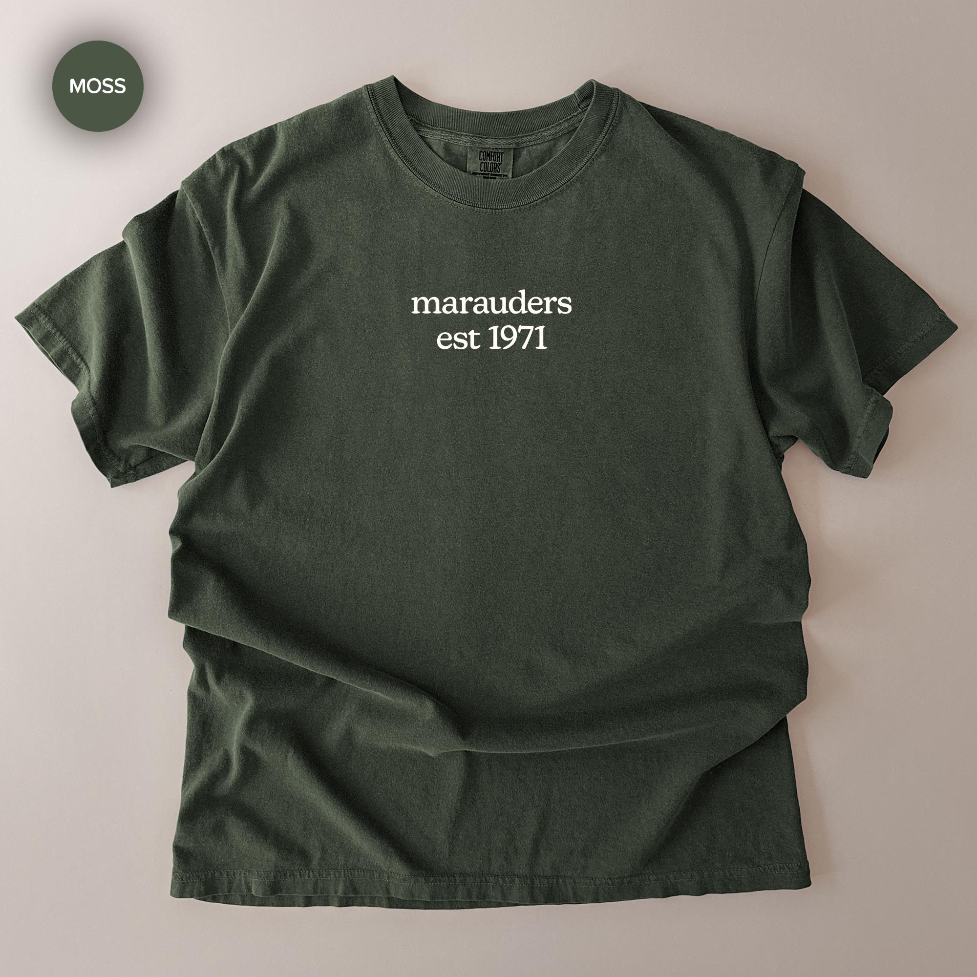 A dark green t-shirt with the text "marauders est 1971" printed on it.
