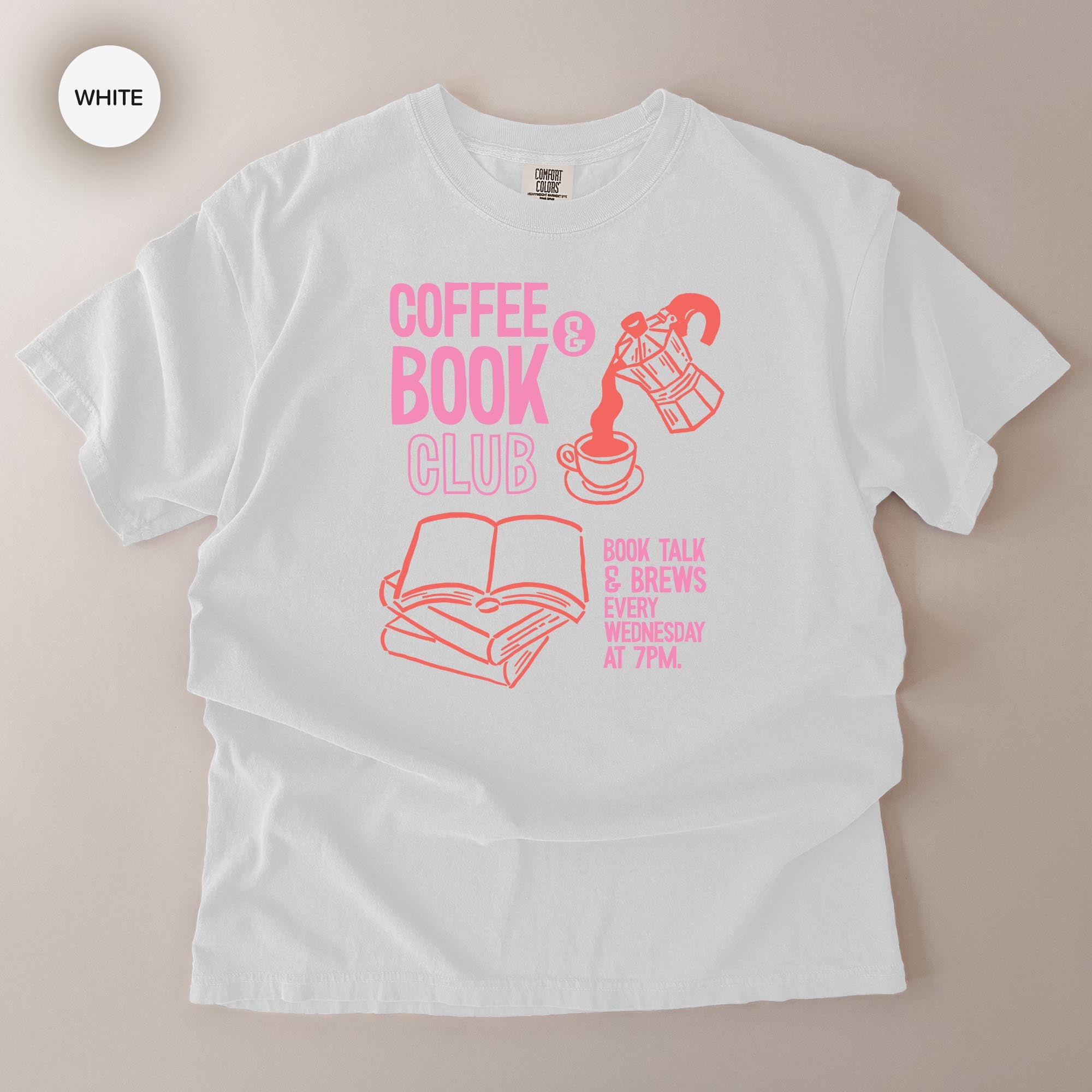 A white t-shirt with a graphic design featuring a coffee cup, a book, and text that reads "COFFEE BOOK CLUB BOOK TALK & BREWS BOOK TALK WEDNESDAY 7PM".