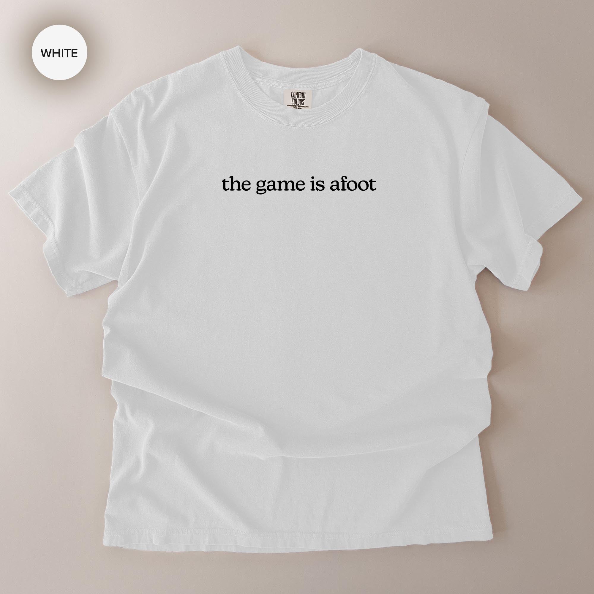 A white t-shirt with the text "the game is afoot" printed on it.
